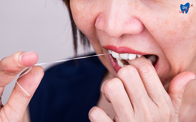 Woman flossing around her teeth